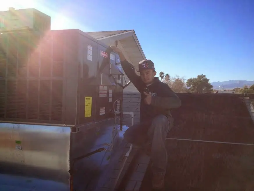 HVAC technician performing HVAC Inspection on a rooftop unit in Greendale
